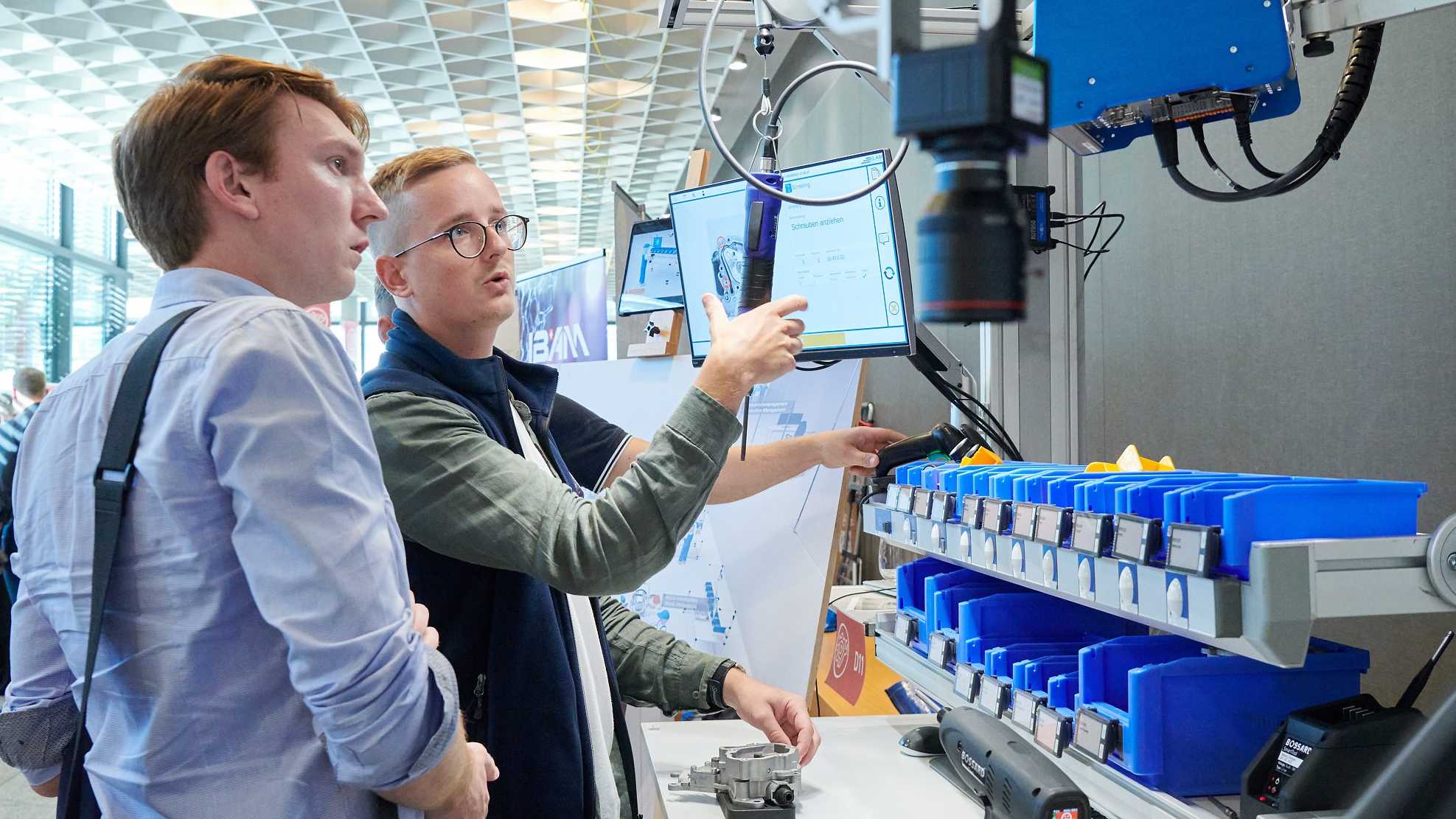 Zwei Studenten diskutieren an einer Maschine