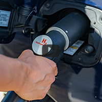 person filling up car with hydrogen