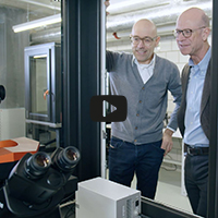 two men looking at a microscope