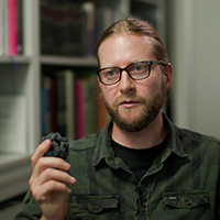 researcher holding enlarged model of the protein cage