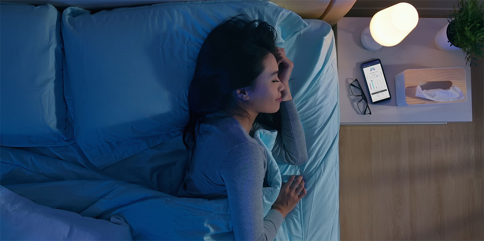 woman sleeping with resmonic's app on mobile phone