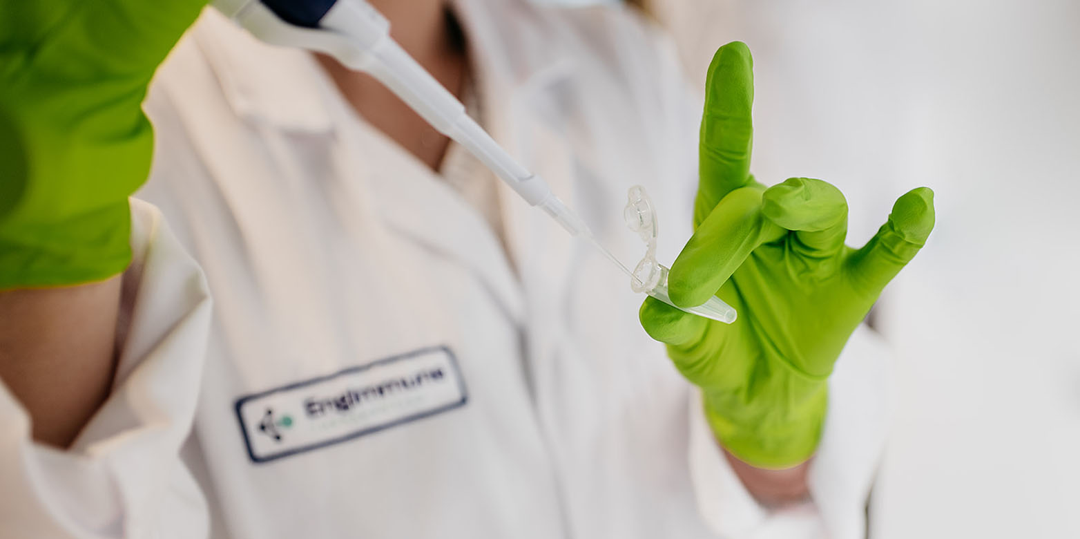 Person spritzt Flüssigkeit in ein Reagenzglas