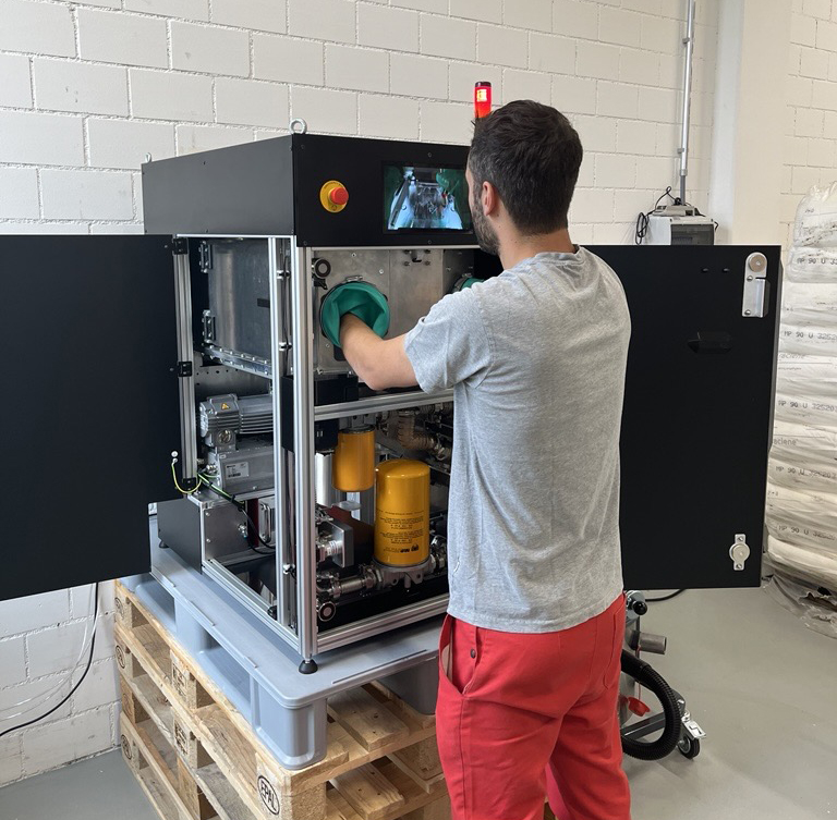 Man in front of 3d printer with hands inside the machine.